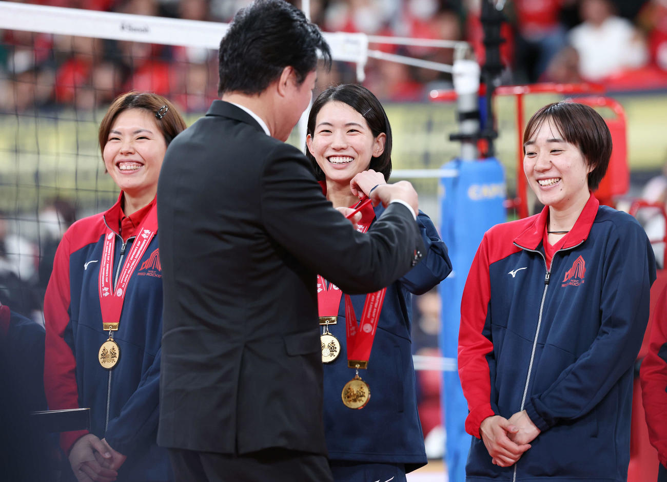 NEC対久光　全日本選手権を制し、川合会長（中央左）から優勝メダルをかけられ、笑顔を見せるNEC古賀（同右）。左は島村、右は塚田（撮影・宮地輝）
