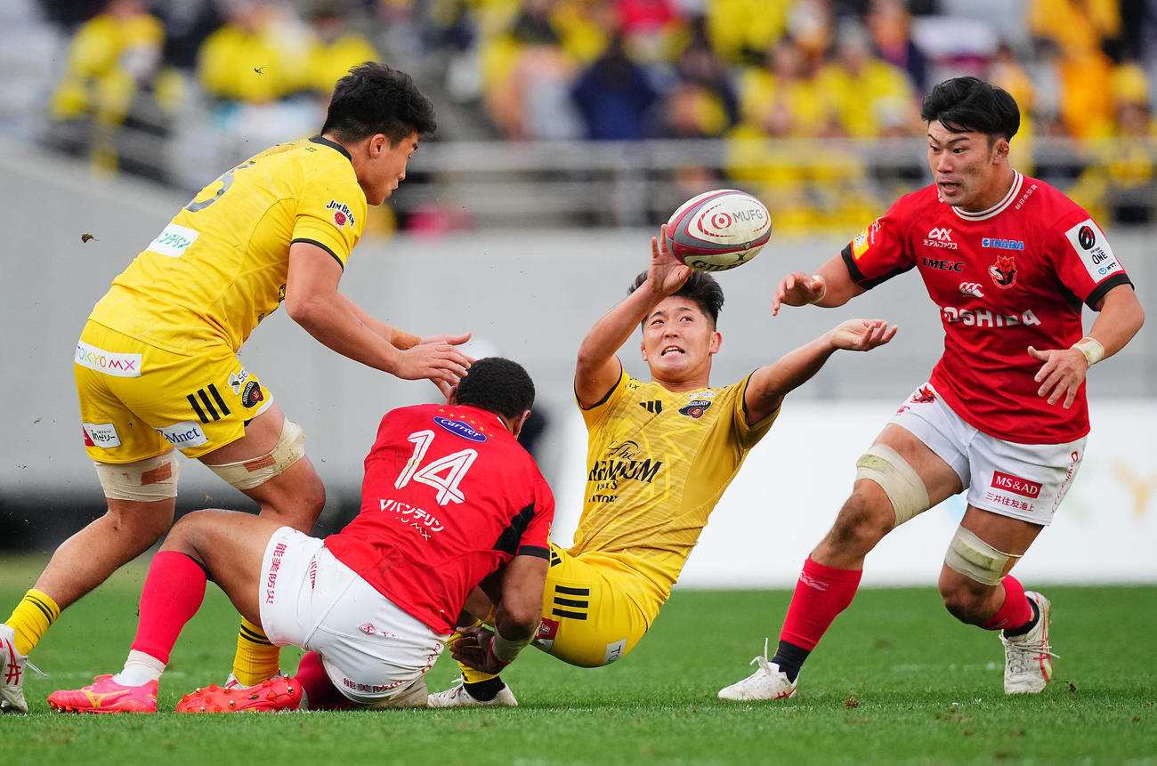 東京SG対BL東京　後半、タックルを受け倒れ込みながらもパスを出す東京SG・SO高本（中央）（撮影・垰建太）