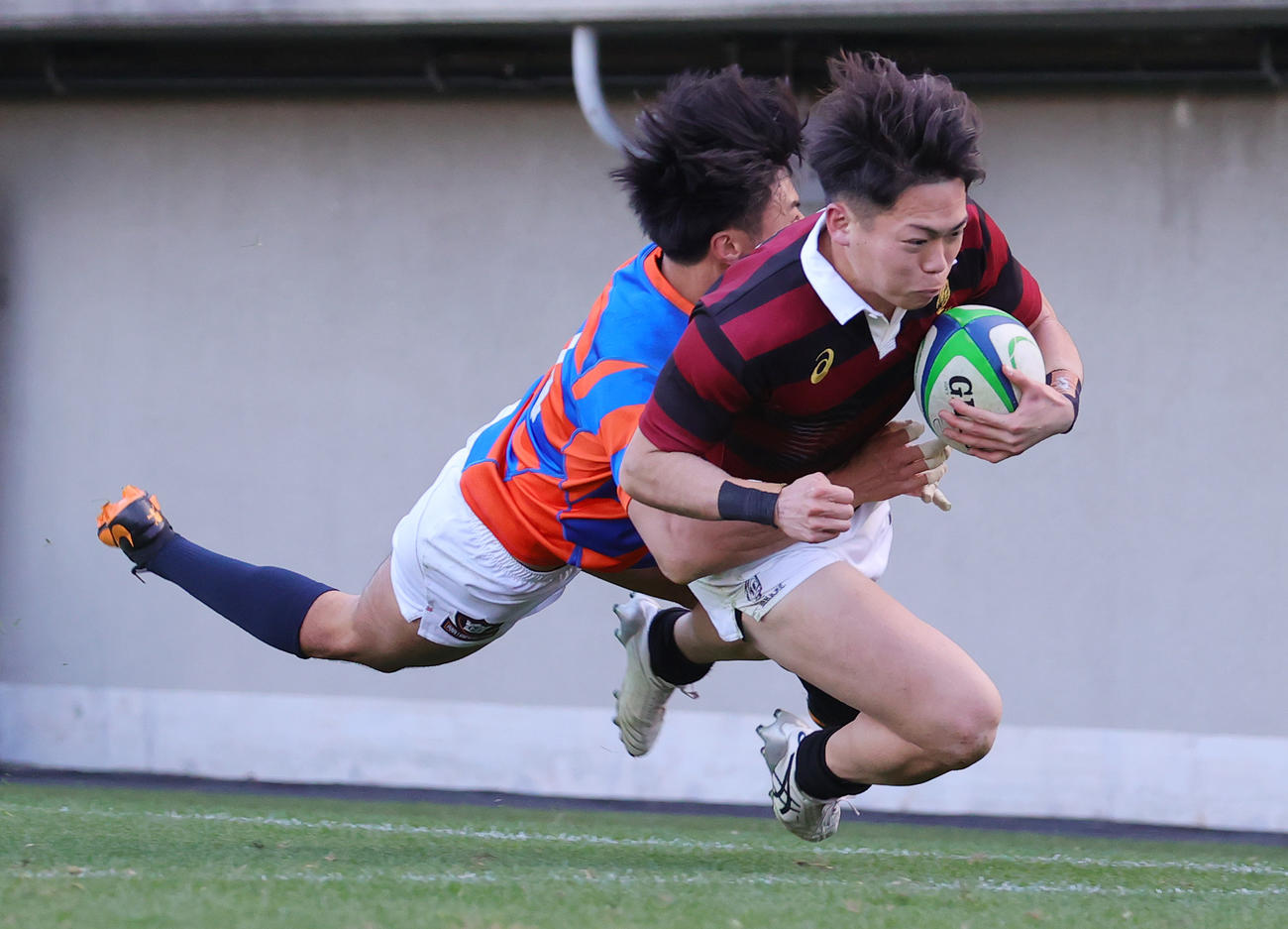 早大対法大　後半、法大WTB石岡のタックルを受けながらトライを決める早大CTB守屋（撮影・野上伸悟）