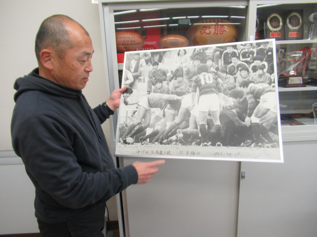 「自分が9歳で見にいきました」と京産大が大学選手権に初出場した82年時のパネルを掲げる広瀬監督