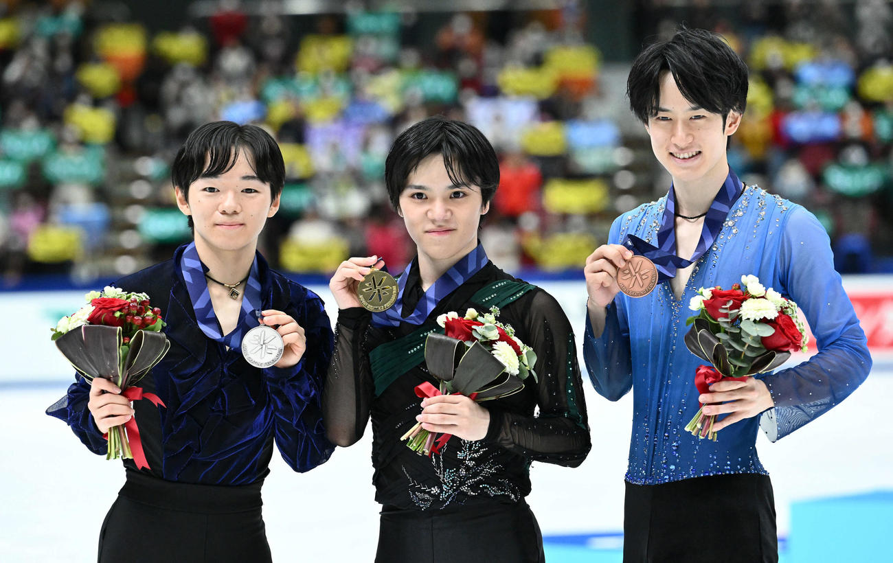 優勝を決め金メダルを手に記念撮影する宇野。左は2位の鍵山。右は3位の山本（撮影・滝沢徹郎）