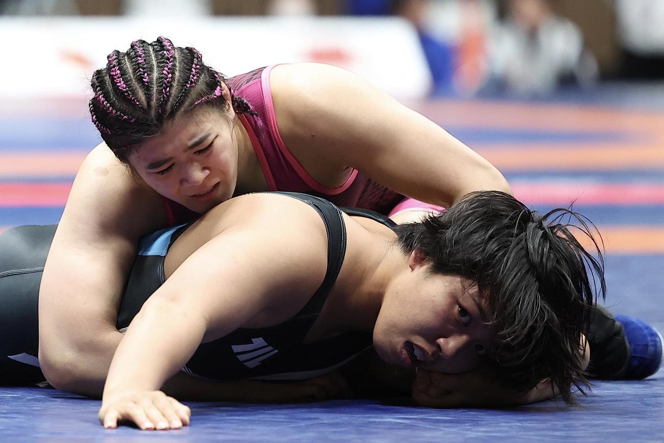 女子68キログラム級1回戦　尾崎（上）の攻めに耐える石井（撮影・河田真司）
