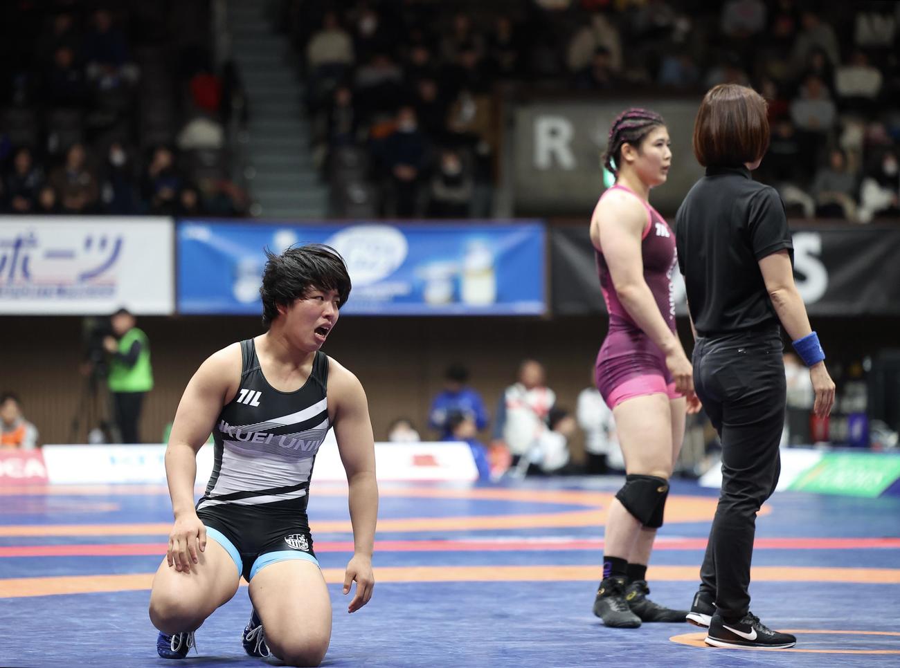 女子68キログラム級1回戦　尾崎（奥）に敗れ肩を落とす石井（撮影・河田真司）
