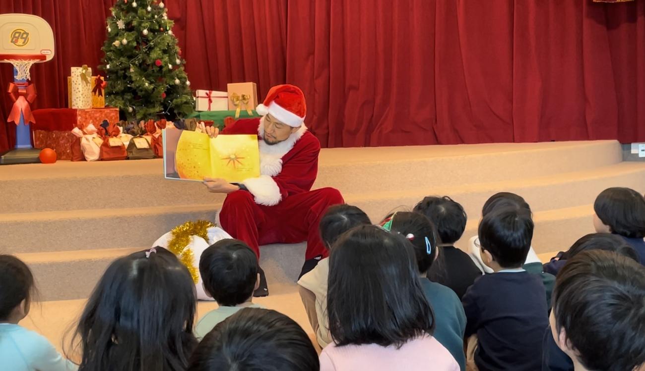 園児たちに読み聞かせをするソルジャーサンタ（仙台89ERS提供）