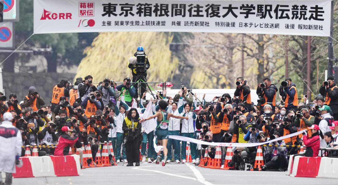 1位でゴールする10区宇田川（手前）を迎える青学大・原監督（中央）ら選手たち（撮影・菅敏）