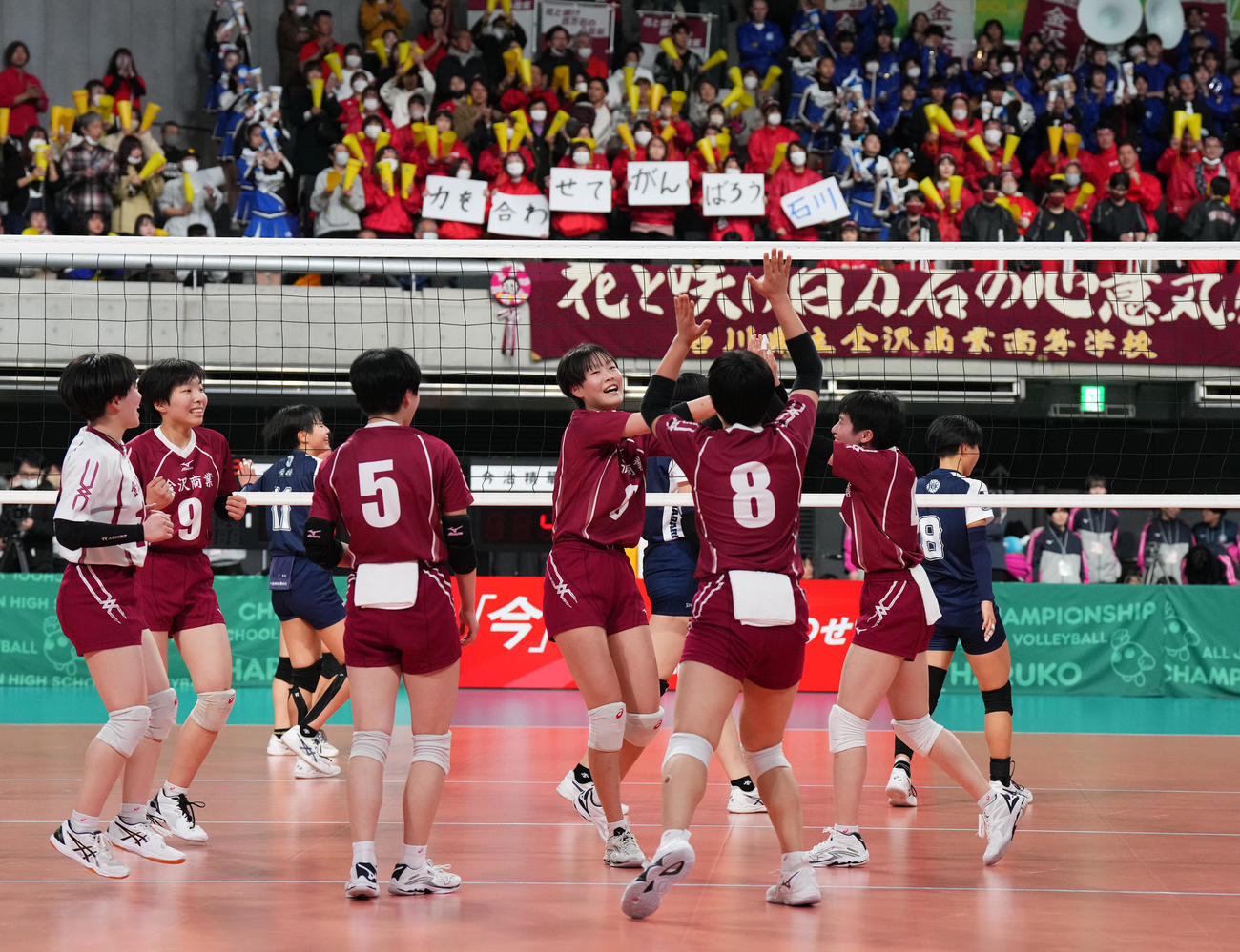 金沢商対今治精華　第2セット、「力を合わせてがんばろう石川」と掲げられたメッセージを前にポイントを奪い喜ぶ金沢商の選手たち（撮影・菅敏）