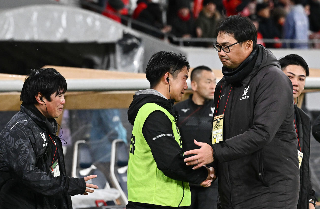 帝京大対明大　優勝を逃し悔しげな表情でスタッフと握手する明大・神鳥監督（右）撮影・滝沢徹郎）