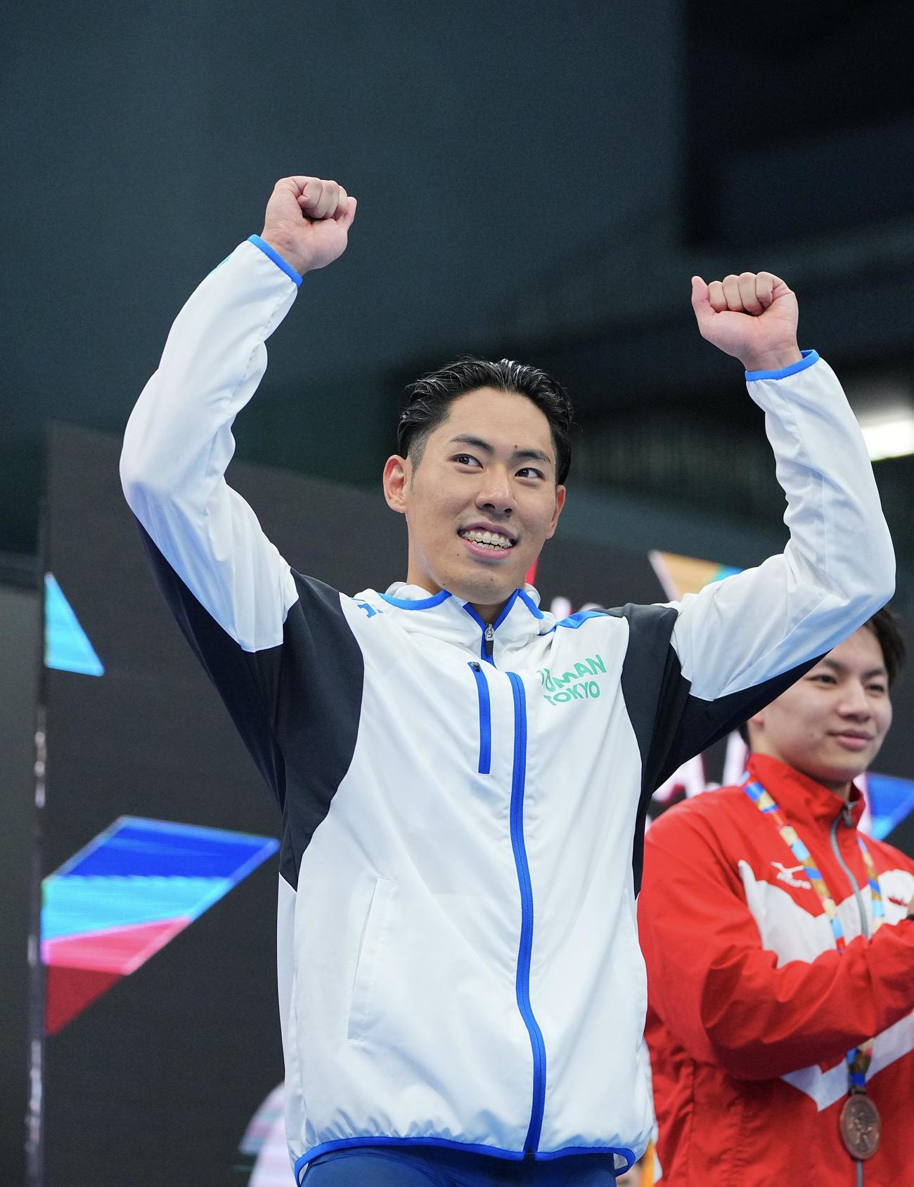 男子200メートルバタフライで優勝し表彰台で笑顔を見せる本多（撮影・垰建太）