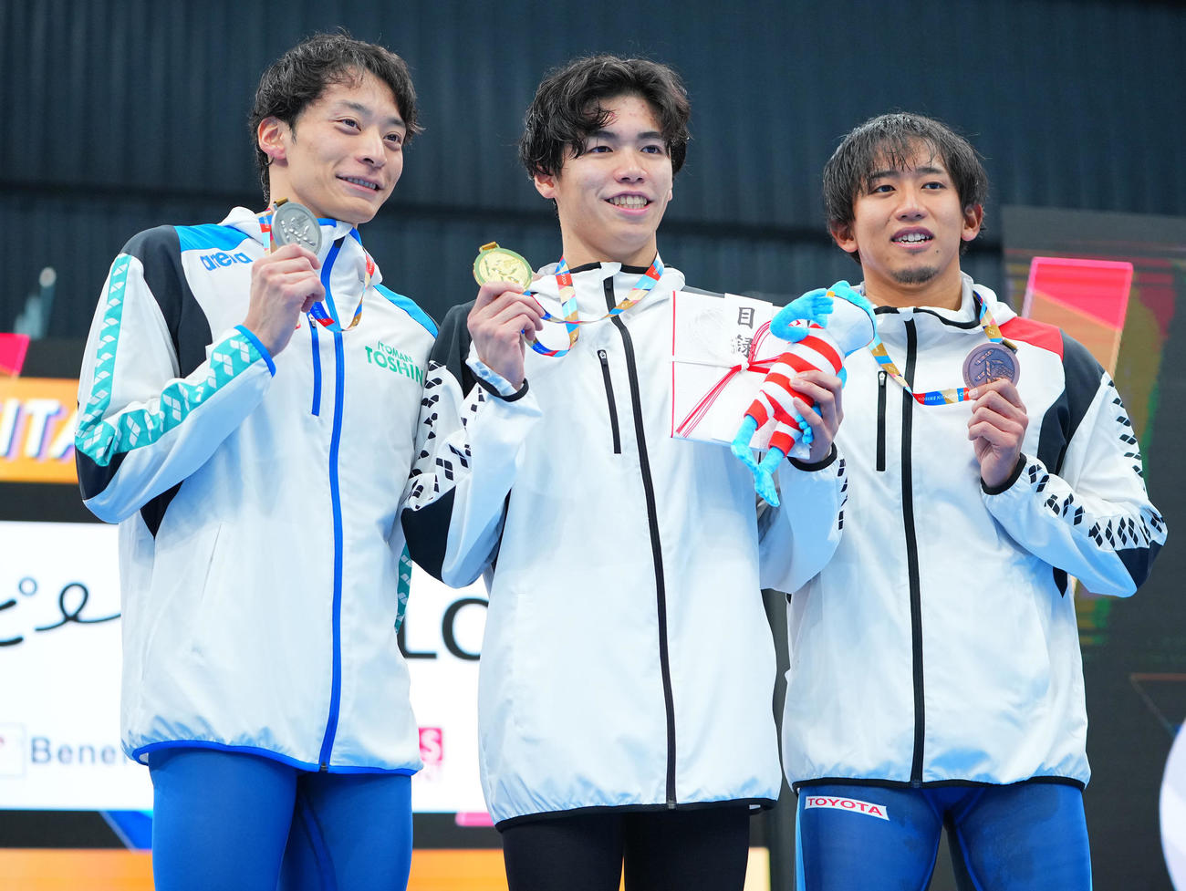 男子100メートル背泳ぎの表彰台で写真に納まる、1位松山（中央）、2位入江（左）、3位川本（撮影・垰建太）