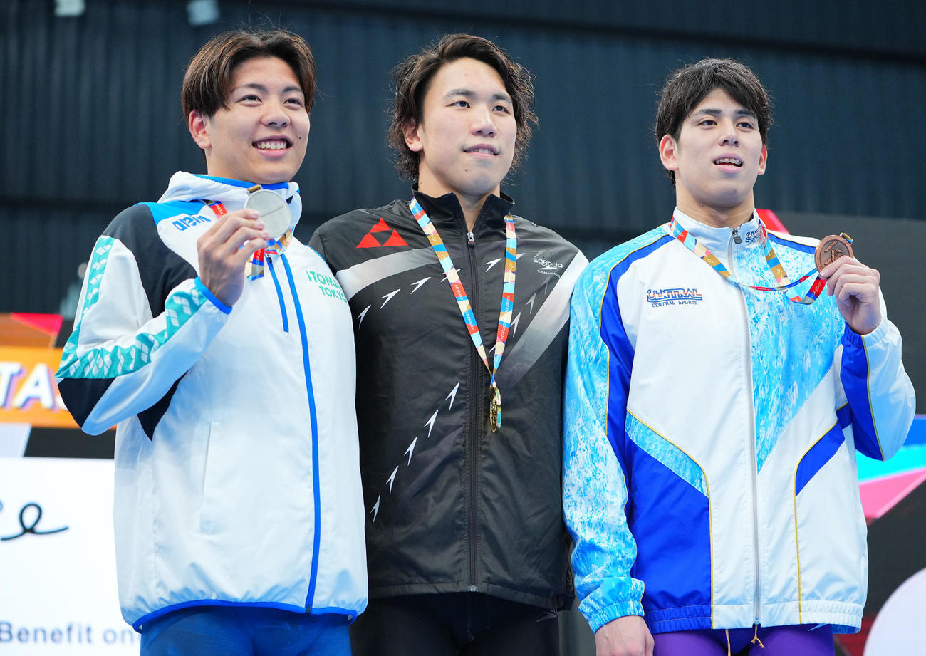 男子200メートル自由形の表彰台で写真に納まる1位松元（中央）、2位柳本（左）、3位真野（撮影・垰建太）