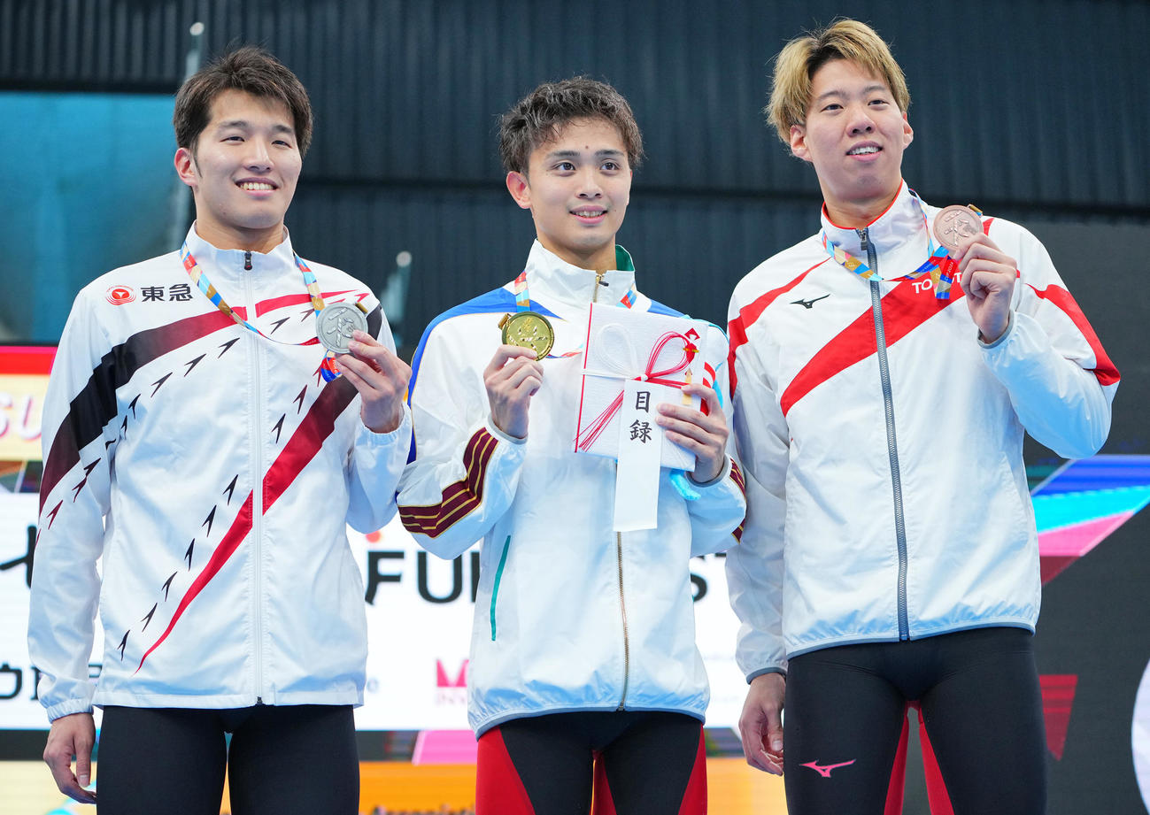 男子100メートル平泳ぎの表彰台で写真に納まる1位花車（中央）、2位深沢（左）、3位渡辺（撮影・垰建太）
