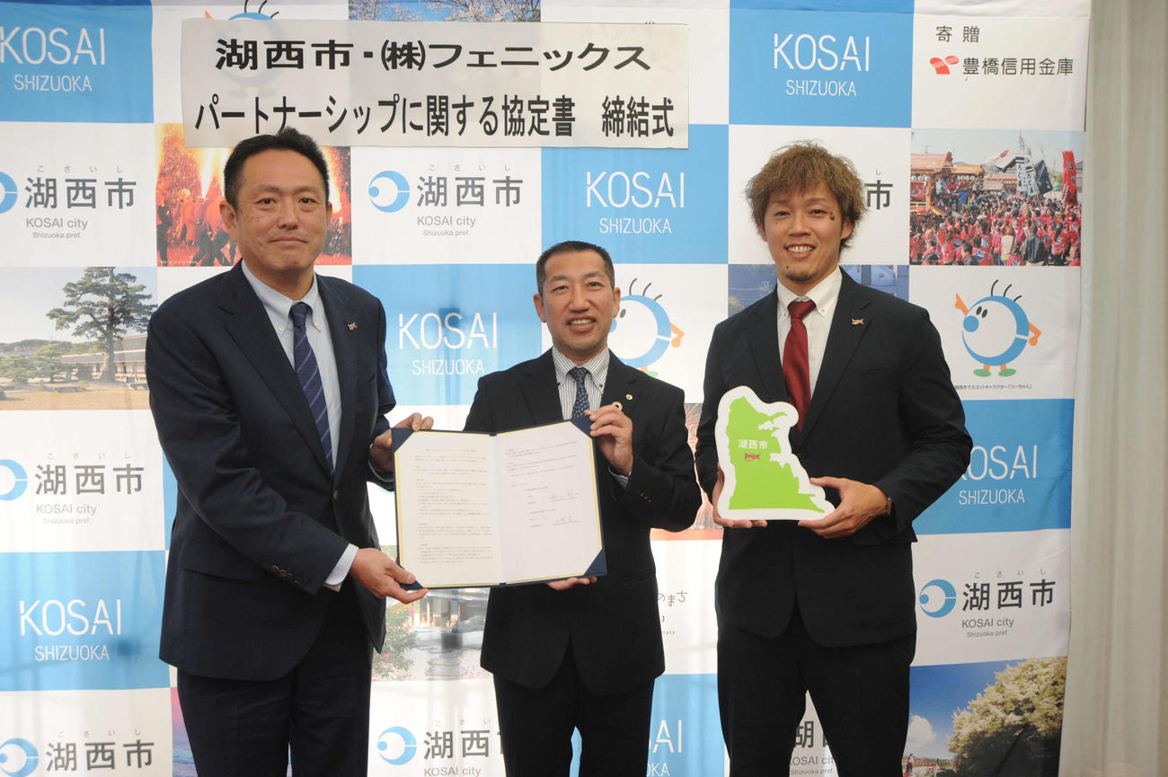 影山湖西市長（中央）と協定書を交わし、記念写真に納まる三遠の水野社長（左）と岡田氏