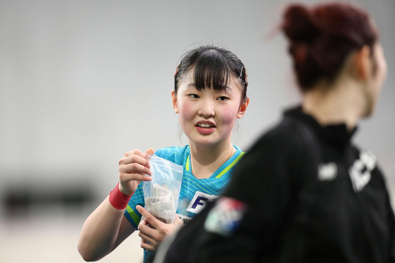 女子シングルス準々決勝を終え、移動する木原（手前）と言葉を交わす張本（撮影・河田真司）