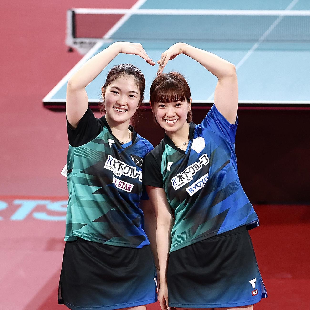 女子ダブルスで優勝を果たし、ハートのポーズで写真に納まる木原（左）と長崎（撮影・河田真司）