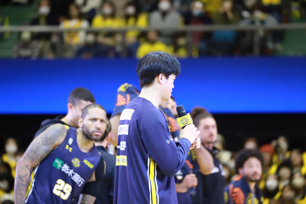 宇都宮対佐賀　ヒーローインタビューでマイクを両手で持つ宇都宮の村岸航と、いぶかしげに見つめるD.J・ニュービル（左）（撮影・沢田啓太郎）