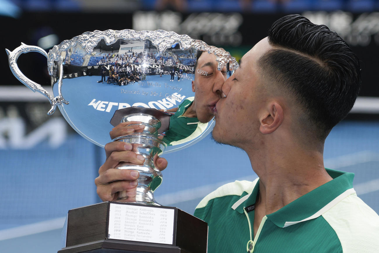 全豪オープン車いすの部を初制覇し、優勝カップにキスする小田凱人（AP）