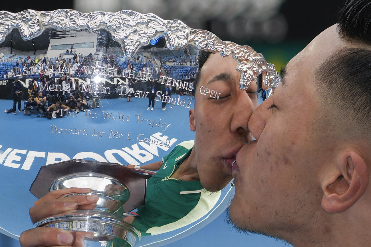 全豪オープン車いすの部を初制覇し、優勝カップにキスする小田凱人（AP）