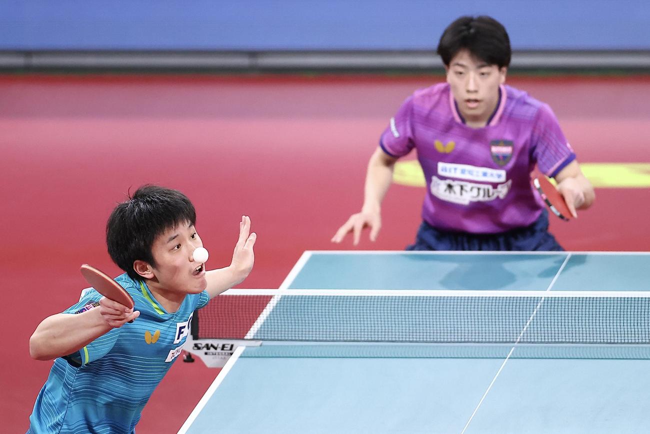 男子シングルス準決勝、篠塚（奥）にサーブを放つ張本（撮影・河田真司）