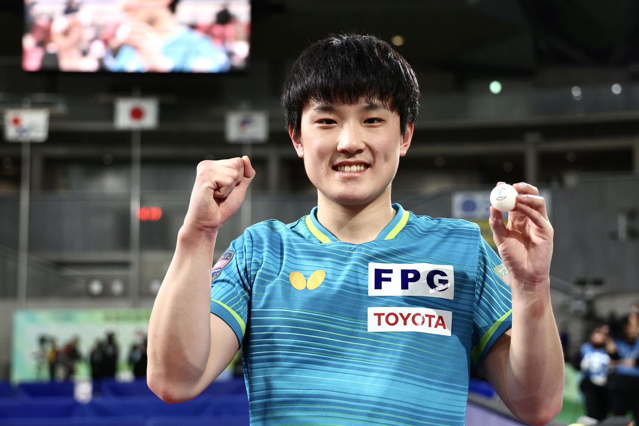 男子シングルス優勝を決め、ウイニングボールを手にガッツポーズで写真に納まる張本（撮影・河田真司）