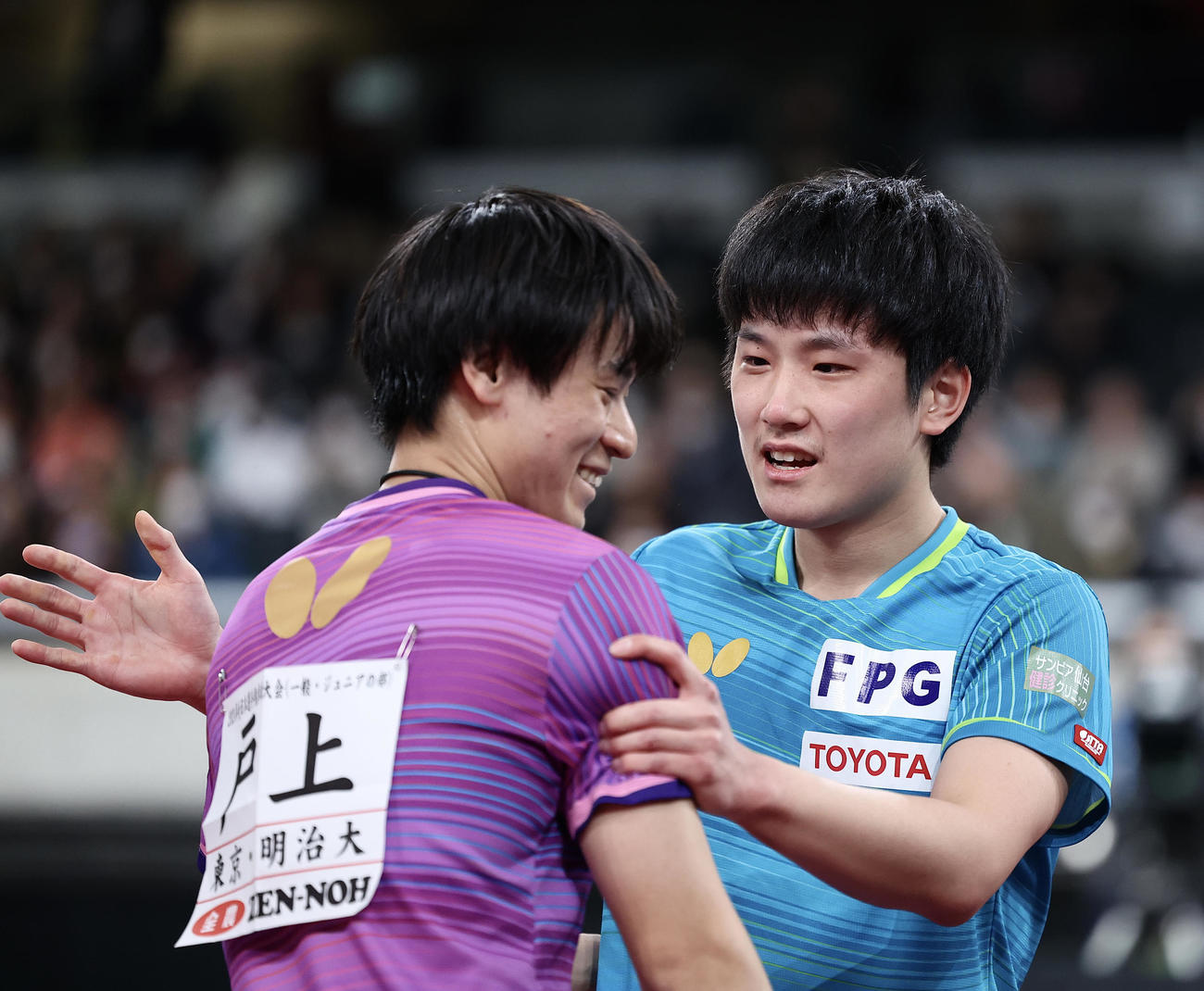 男子シングルス決勝　戸上（左）に勝利し、健闘をたたえ合う張本（撮影・河田真司）