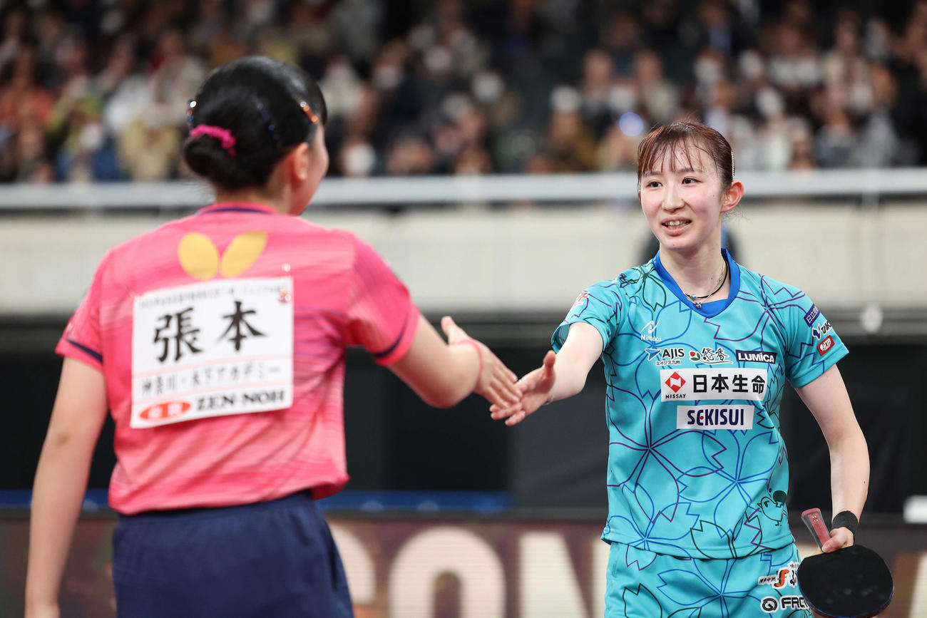 女子シングルス決勝、張本（手前）に勝利し、握手を交わす優勝した早田（撮影・河田真司）