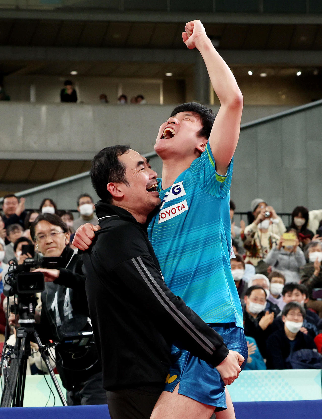 男子シングルスで優勝を果たし、董崎岷コーチ（左）と抱き合い歓喜する張本（撮影・河田真司）