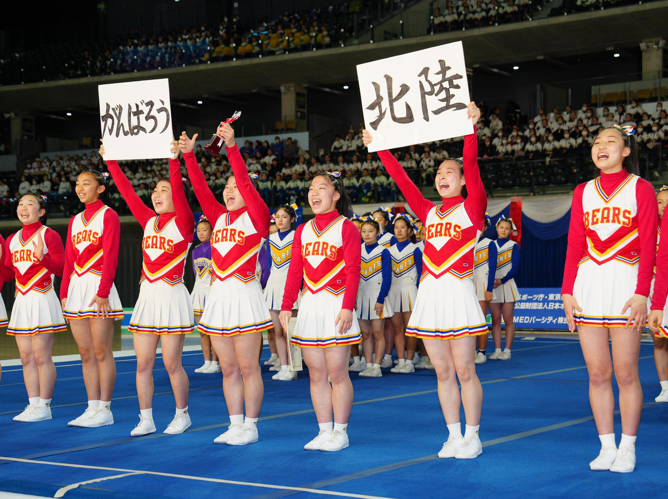 表彰式で「がんばろう」「北陸」のボードを掲げる自由演技ディビジョン2で優勝した箕面自由学園の選手たち（撮影・江口和貴）
