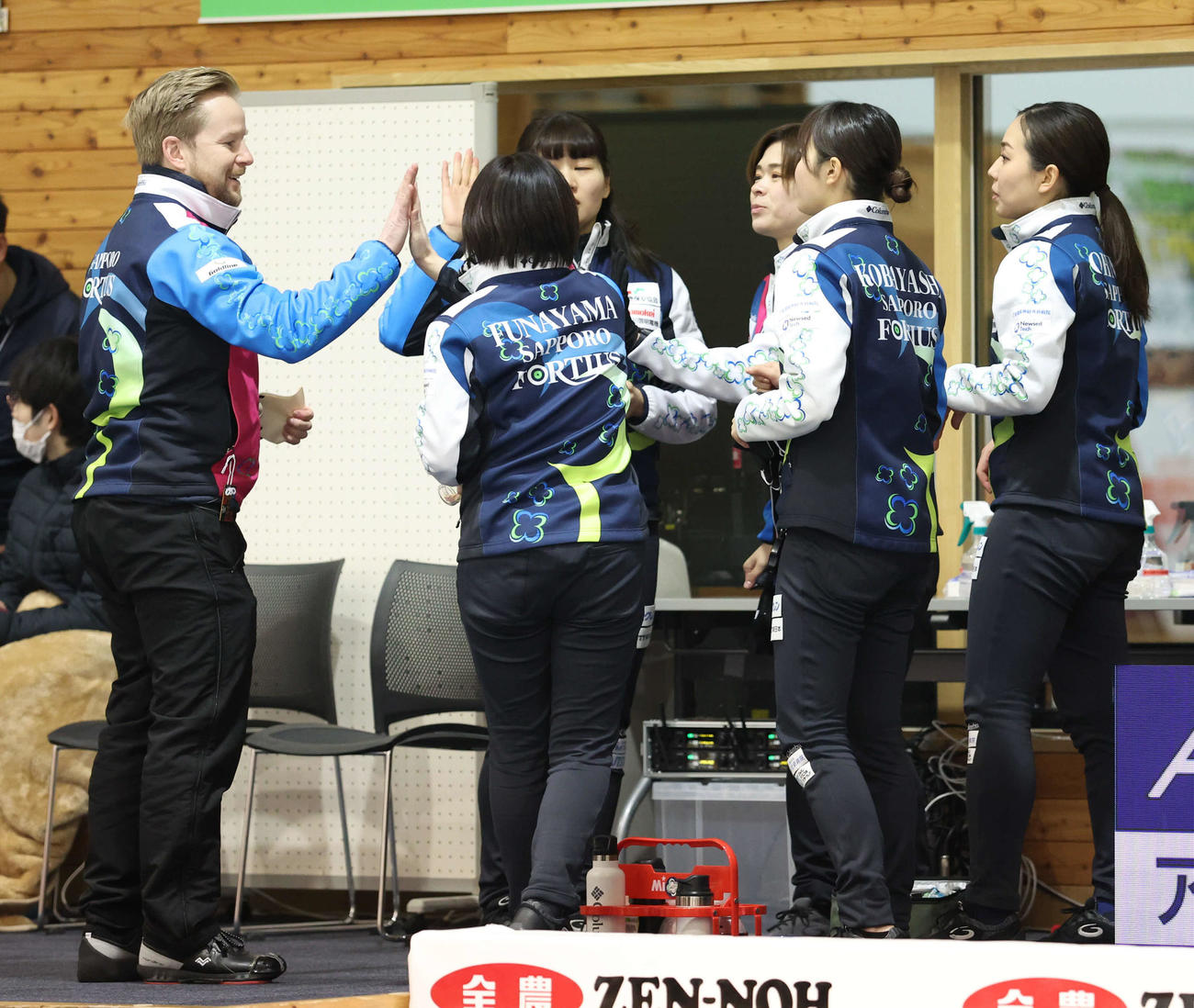 フォルティウス対チーム広島　第5エンド後、選手たちとハイタッチをするフォルティウスのエディンコーチ（左）（撮影・佐藤翔太）