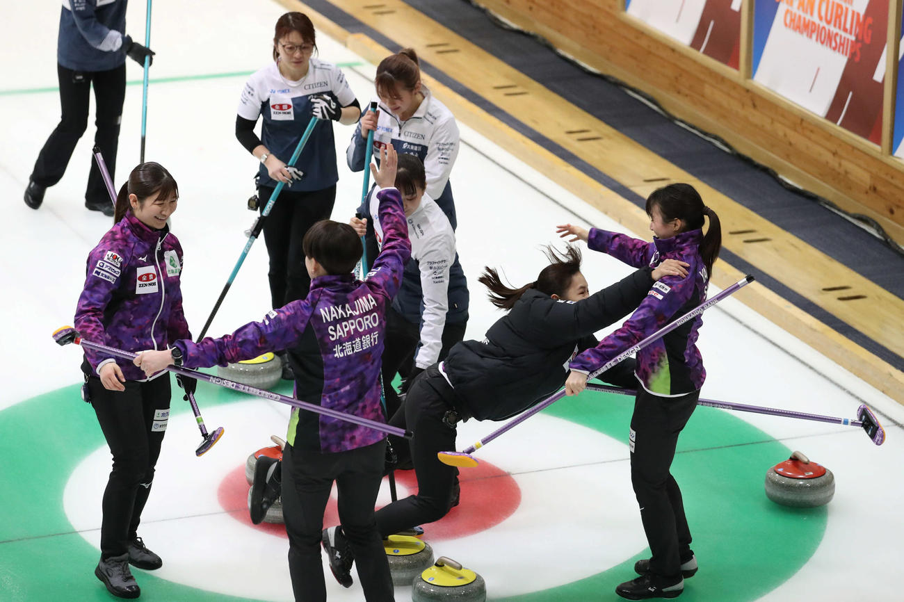 SC軽井沢クラブ対北海道銀行　SC軽井沢クラブに勝利し喜ぶあまりストーンにつまづいてしまう北海道銀行の仁平（中央）（撮影・佐藤翔太）