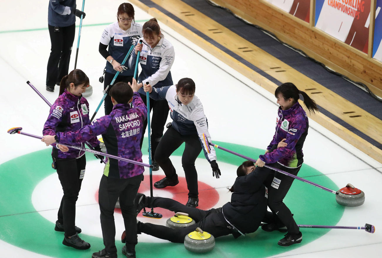 SC軽井沢クラブ対北海道銀行　SC軽井沢クラブに勝利し喜ぶあまりストーンにつまづいてしまう北海道銀行の仁平（中央）（撮影・佐藤翔太）