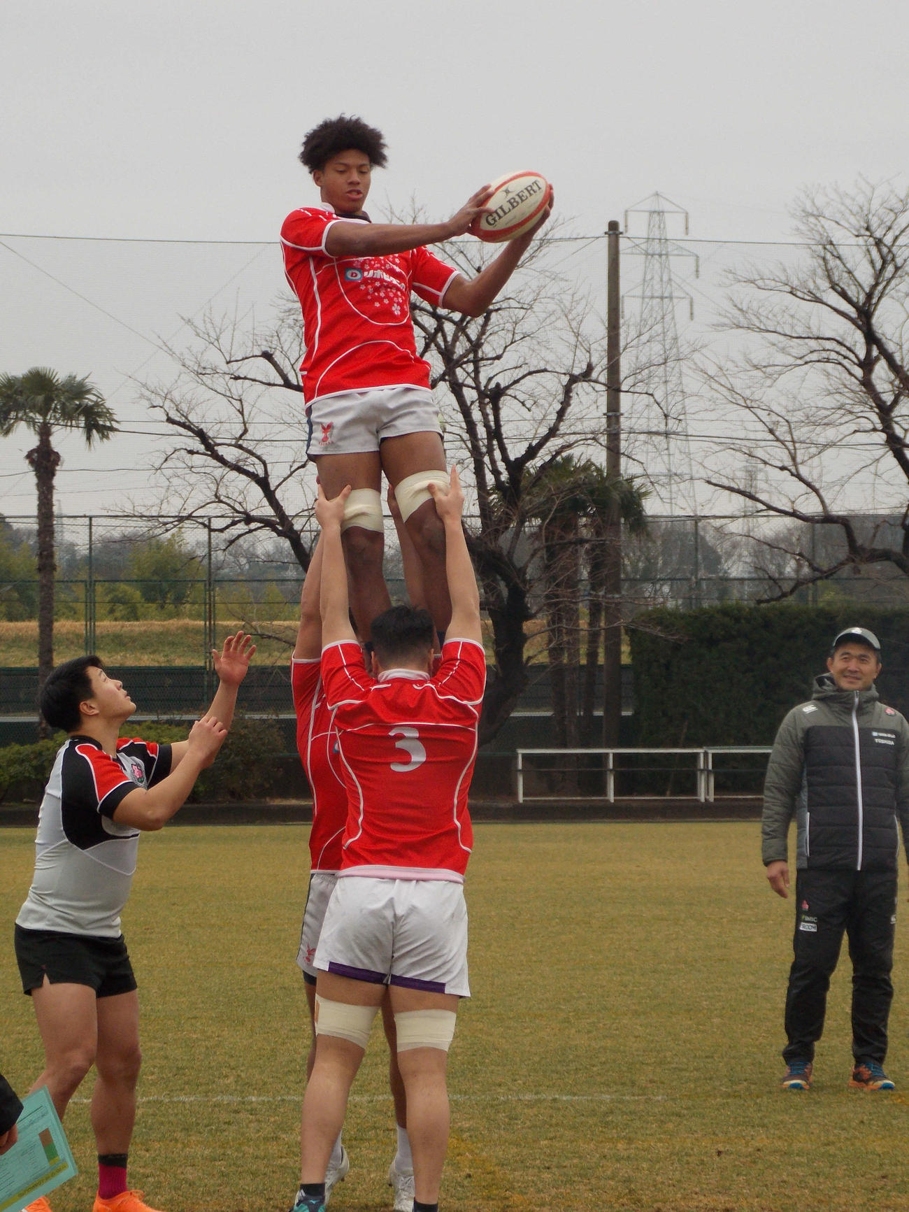 U20日本代表候補FW合宿のラインアウト練習で捕球するロックの石橋チューカと、見守る大久保直弥ヘッドコーチ（右）（撮影・松本航）