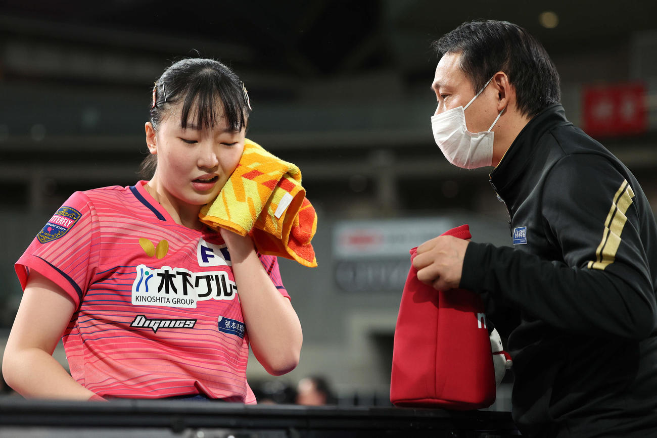 女子シングルス決勝　父の宇コーチ（右）のアドバイスを聞く張本（撮影・河田真司）