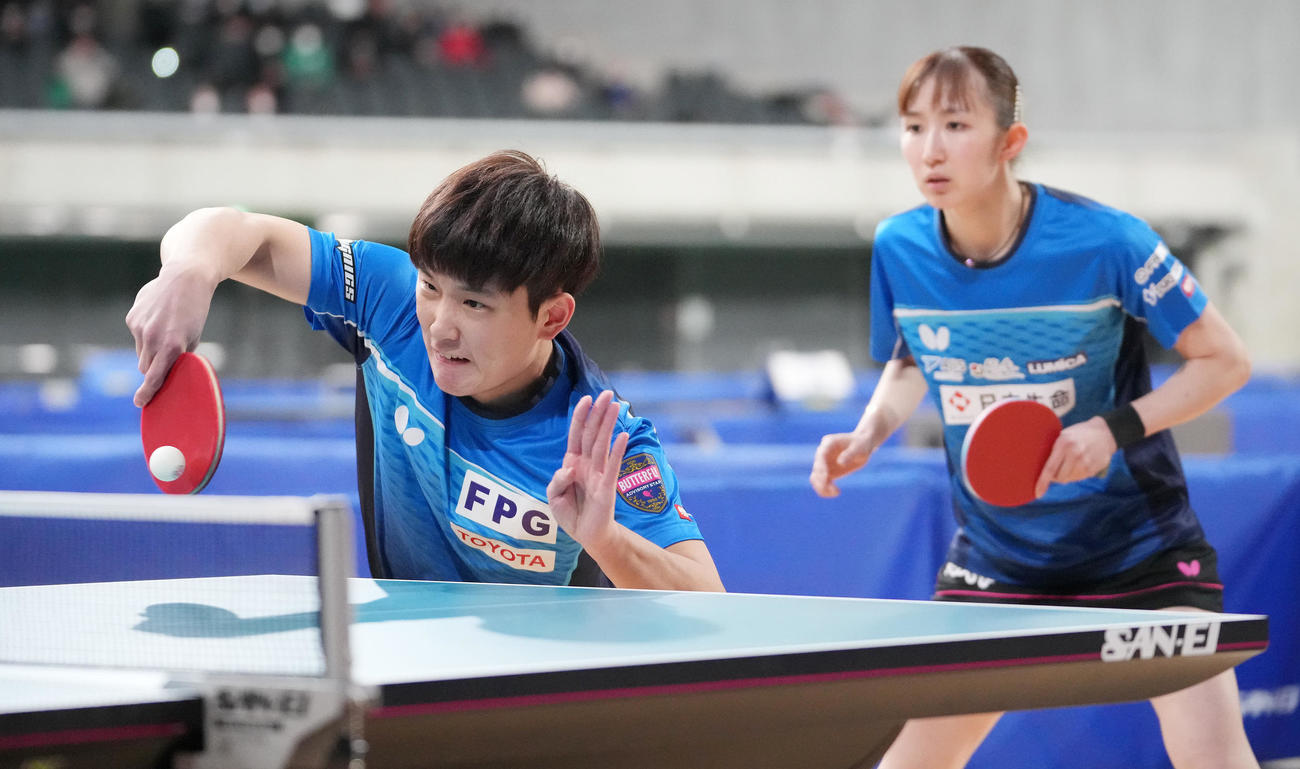卓球全日本選手権の混合ダブルス決勝　第1ゲーム、打ち返す張本智。右は早田（2023年1月26日撮影）