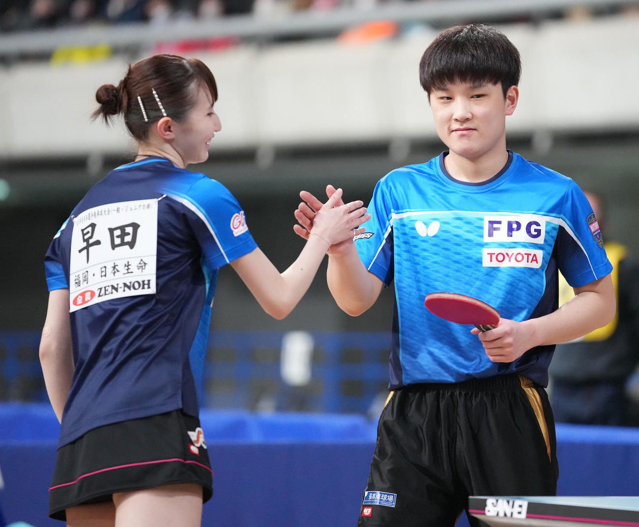 卓球全日本選手権の混合ダブルス決勝で勝利し2連覇を決め、タッチを交わす張本智（右）、早田組（2023年1月26日撮影）