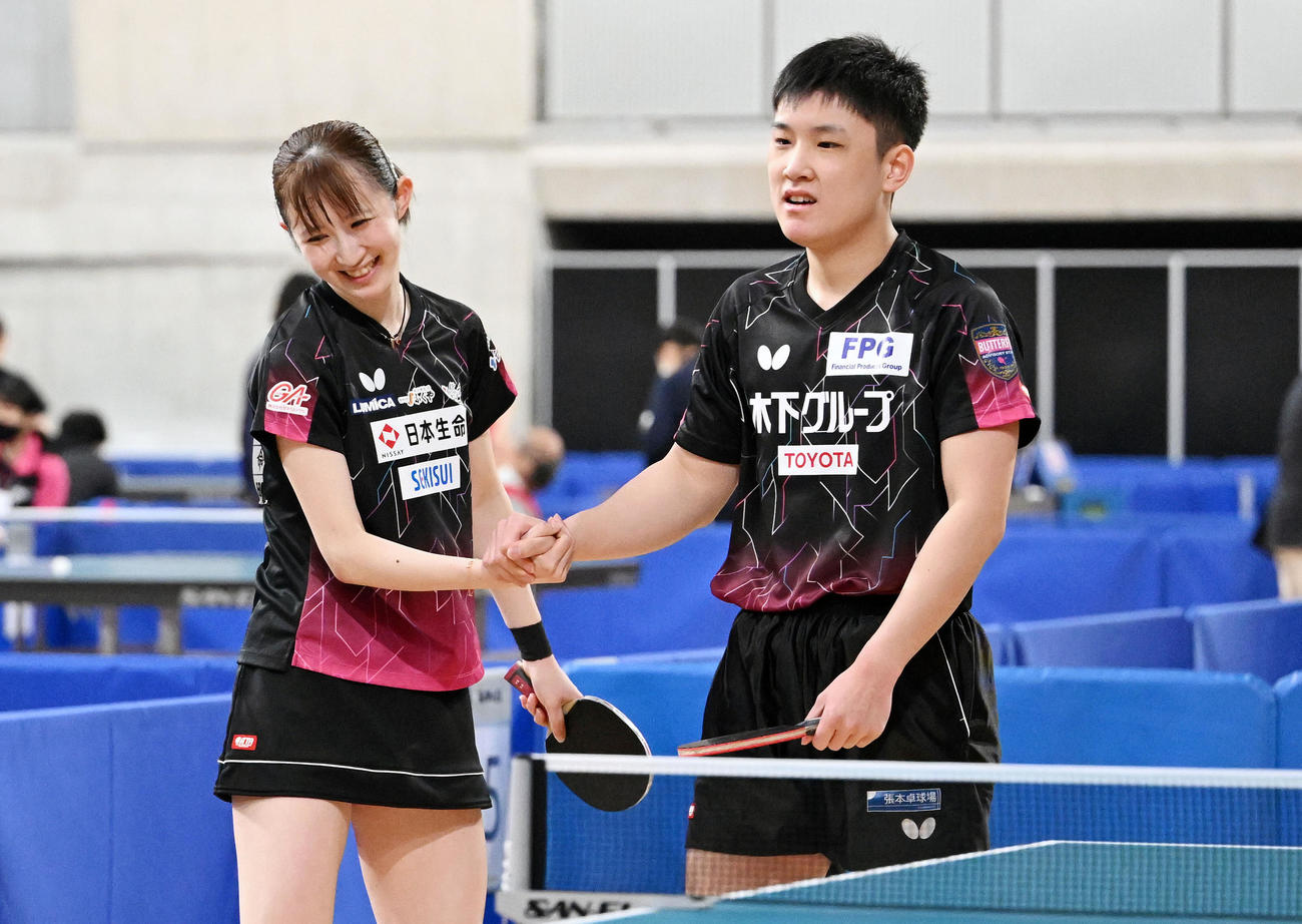 卓球全日本選手権の混合ダブルス4回戦でフルセットの末勝利し笑顔で握手を交わす早田（左）と張本（2022年1月26日撮影）