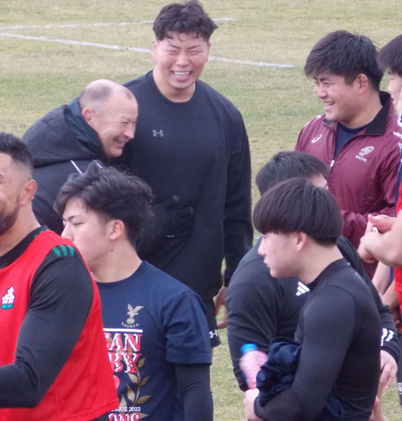 ラグビー日本代表候補の福岡合宿最終日、青木（左から2人目）の腹をさすりながら笑顔を見せるエディー・ジョーンズ・ヘッドコーチ（左）（撮影・松本航）