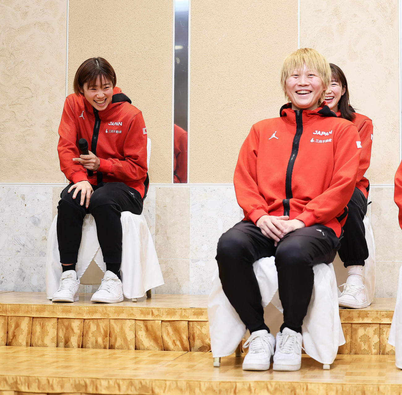 会見で野口（左）を撮影しようとするカメラが自身で隠れていることを気遣い、席をずらす高田（撮影・足立雅史）