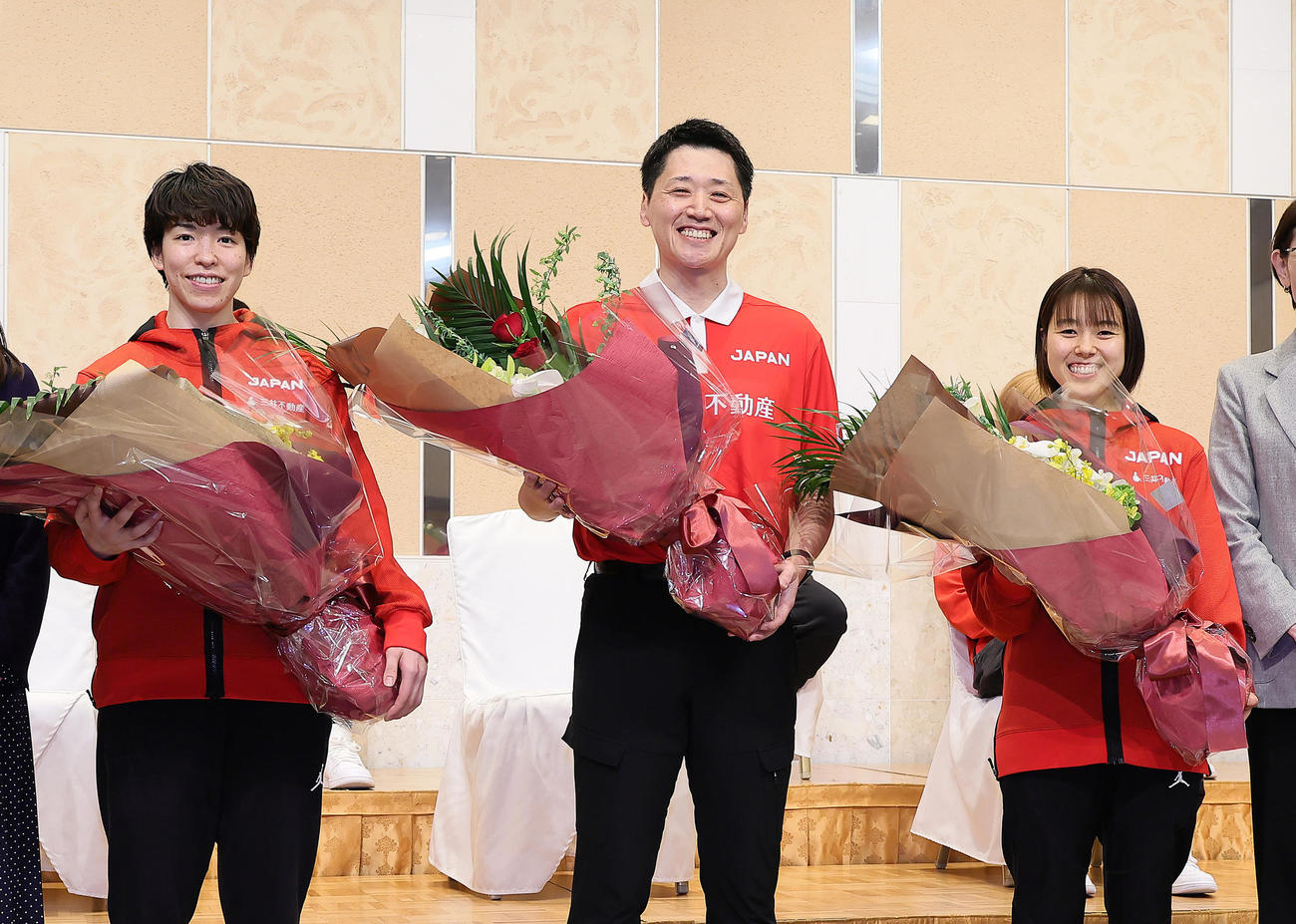 花束を受け取り笑顔を見せる、左からバスケットボール女子日本代表の林主将、恩塚監督、山本（撮影・足立雅史）
