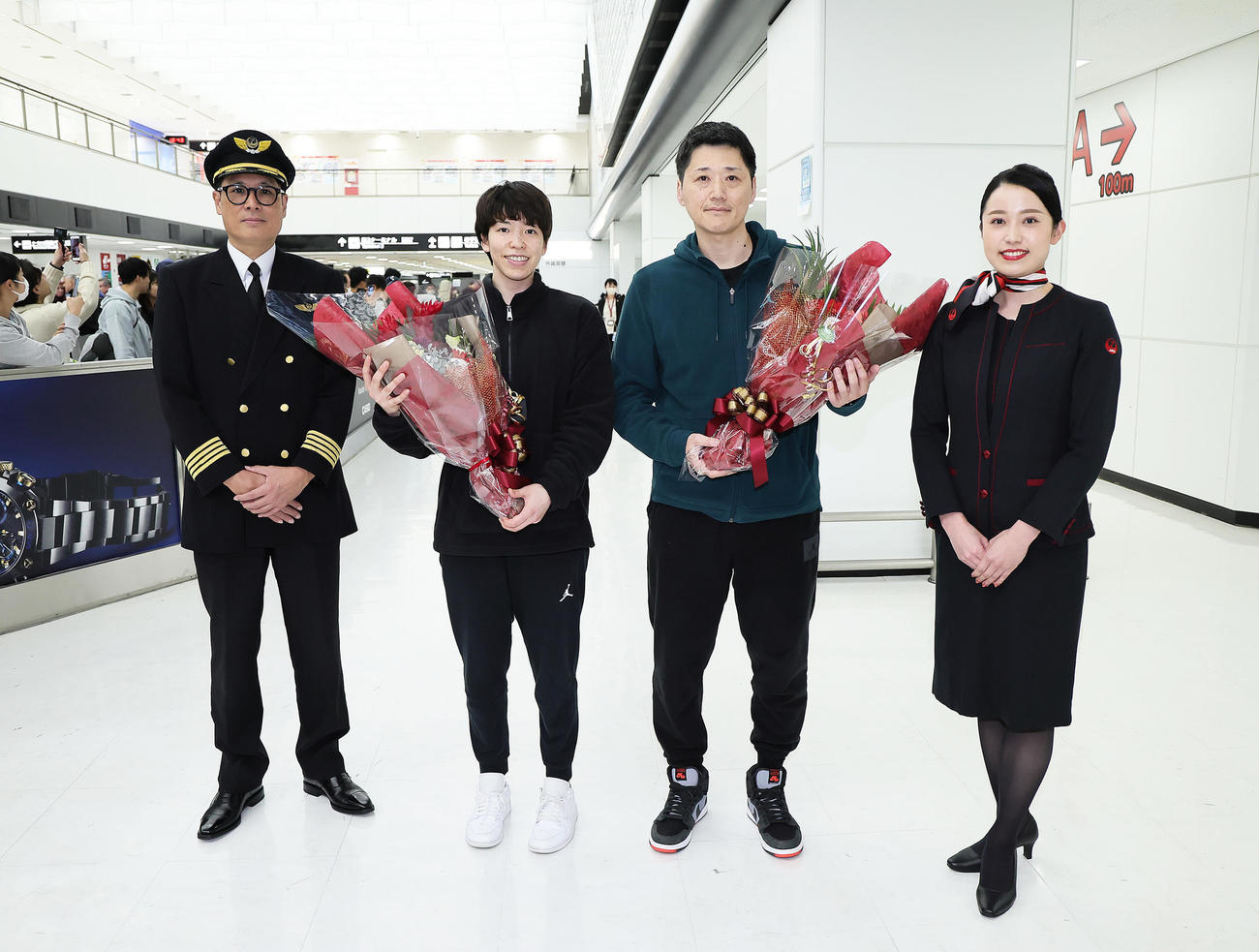 帰国したバスケットボール女子日本代表の林主将（左から2人目）と恩塚監督（同3人目）は日本航空の歓迎セレモニーで笑顔（撮影・足立雅史）