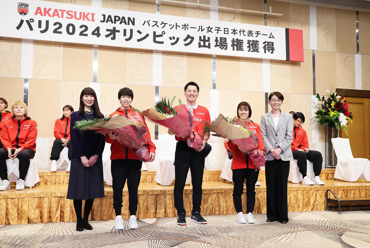 花束を手に記念撮影するバスケットボール女子日本代表選手ら。左からWリーグ原田会長、林、恩塚監督、山本、日本バスケットボール協会の三屋会長（撮影・足立雅史）