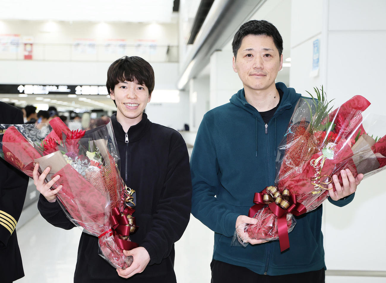 帰国し、空港で花束を受け取るバスケットボール女子日本代表の林主将（左）と恩塚監督（撮影・足立雅史）