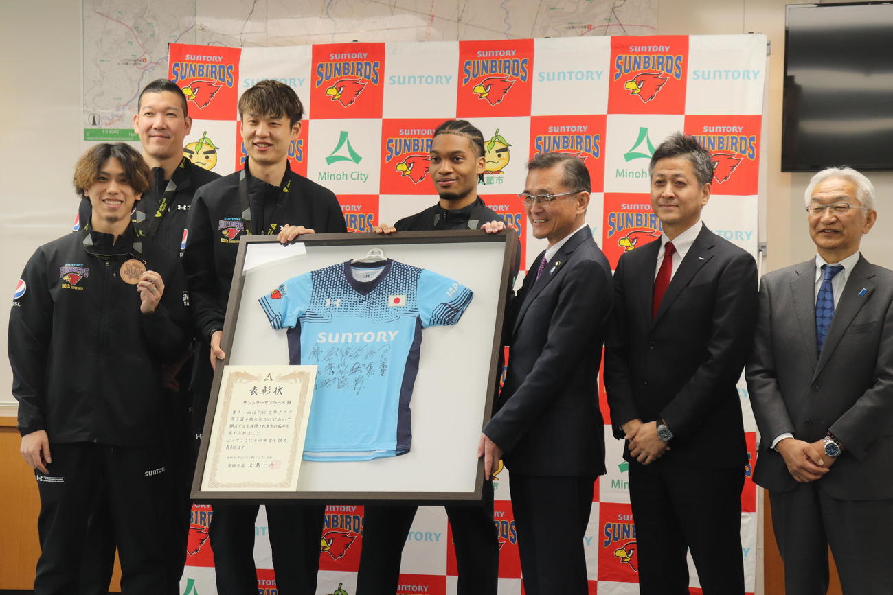 箕面市役所を訪問したサントリーの選手ら。左から大宅、山村監督、小野寺、デ・アルマスアライン、上島市長、栗原GM、藤迫箕面市教育委員会教育長（2023年12月18日撮影）