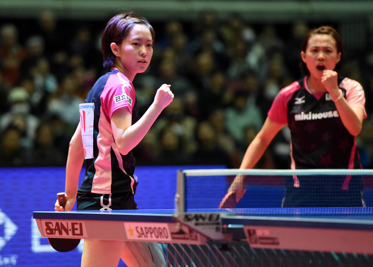 15年1月、卓球全日本選手権・女子ダブルス決勝で、ポイントを奪って鋭い視線で相手をにらむ石川佳純さん。後方は平野早矢香さん