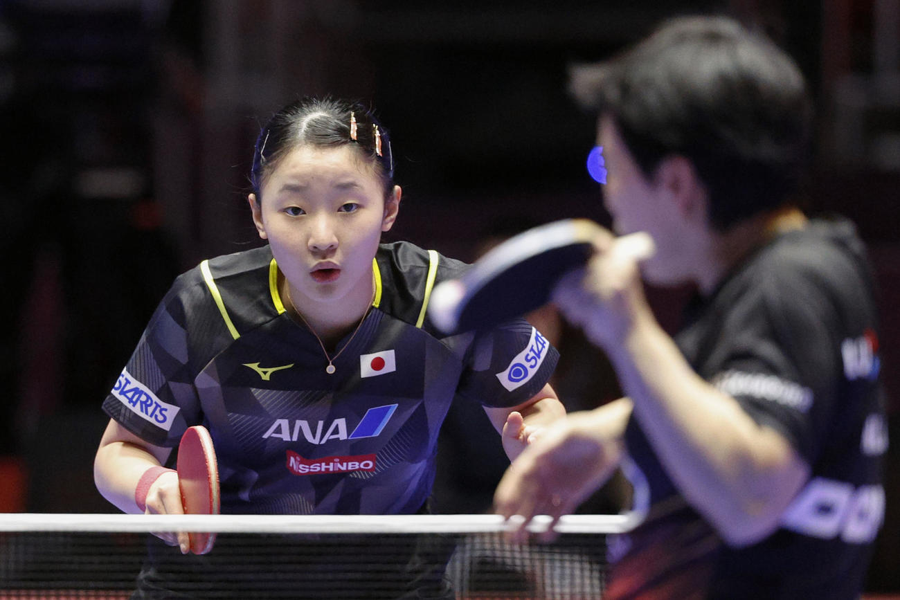 女子1次リーグのルクセンブルク戦で、60歳のシャリャン・ニ（手前）と対戦する15歳の張本。「45歳差」対決をストレートで制した（共同）