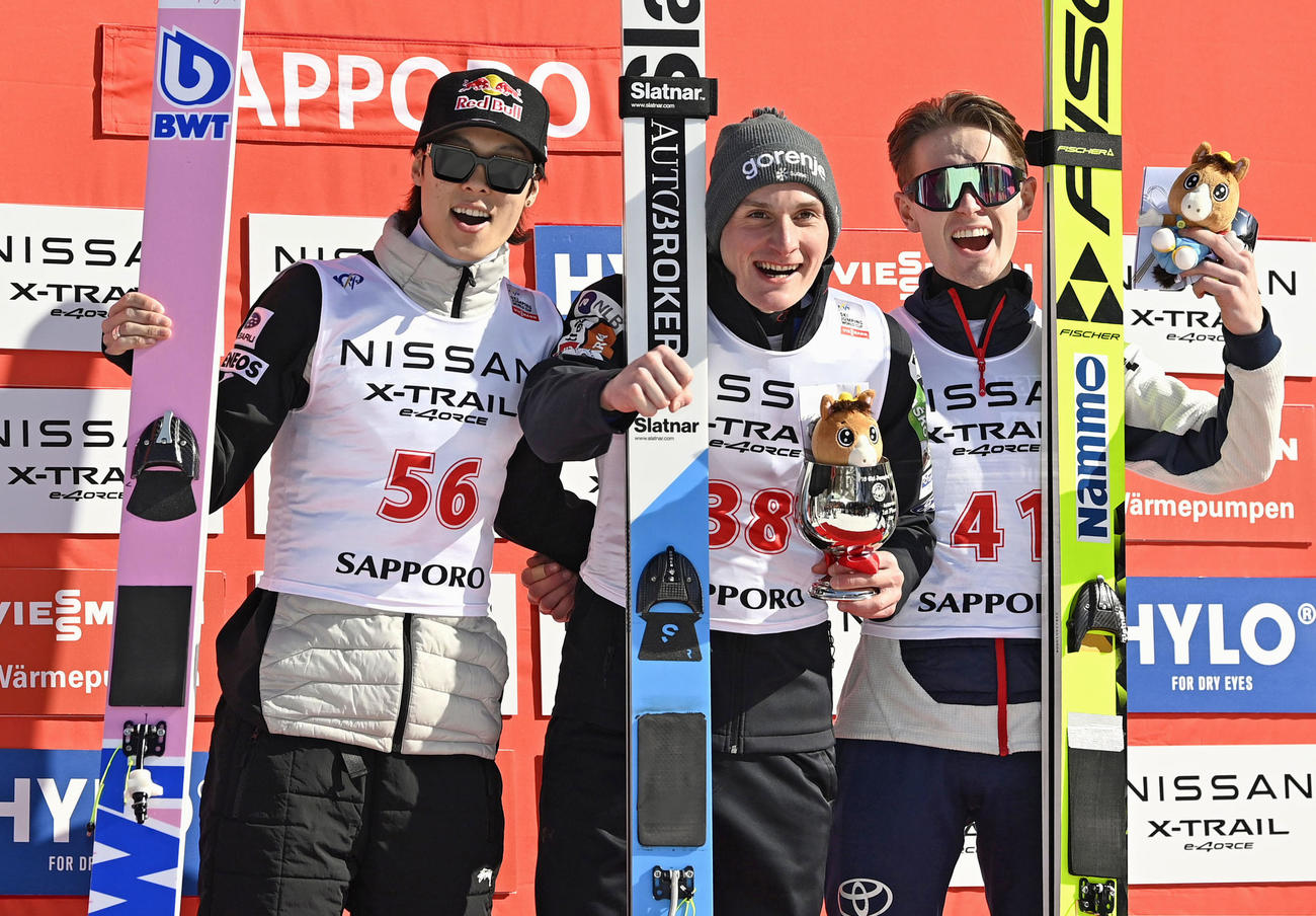 表彰台で記念写真に納まる（左から）2位の小林陵侑、優勝のドメン・プレブツら＝大倉山（共同）