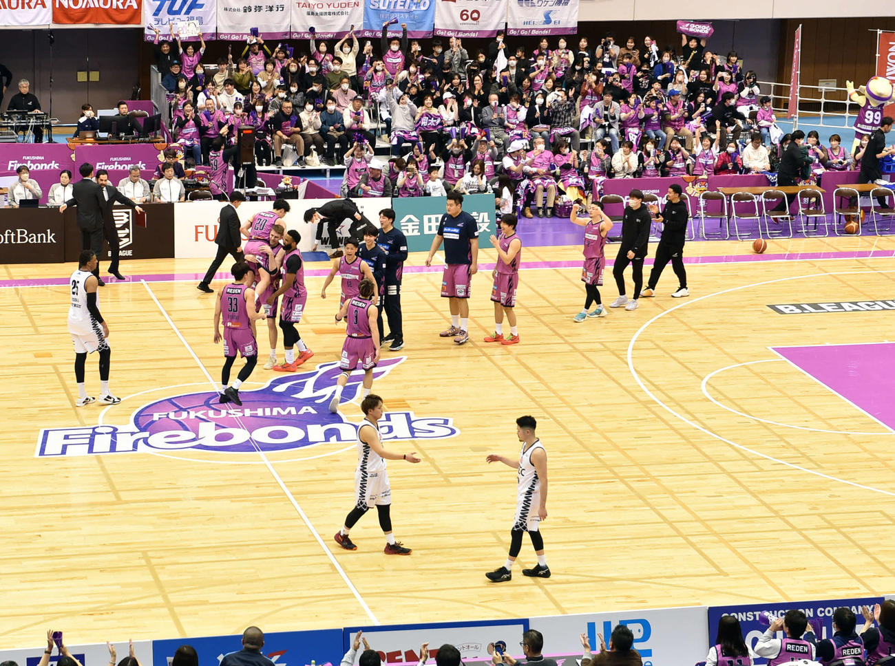 改修前最後の試合で逆転勝利を収め、コートで歓喜する福島の選手たち（後方）（撮影・相沢孔志）