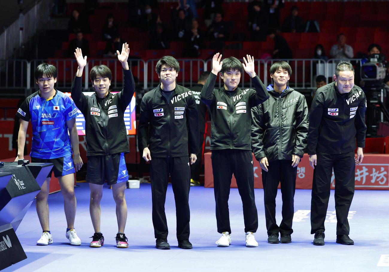 男子2回戦でオーストリアに勝利し8強入りを決め、歓声に応える（右から）田勢邦史監督、戸上隼輔、張本智和、田中佑汰、篠塚大登、松島輝空。パリ五輪の団体出場権とシングルス2枠を獲得した＝釜山（共同）