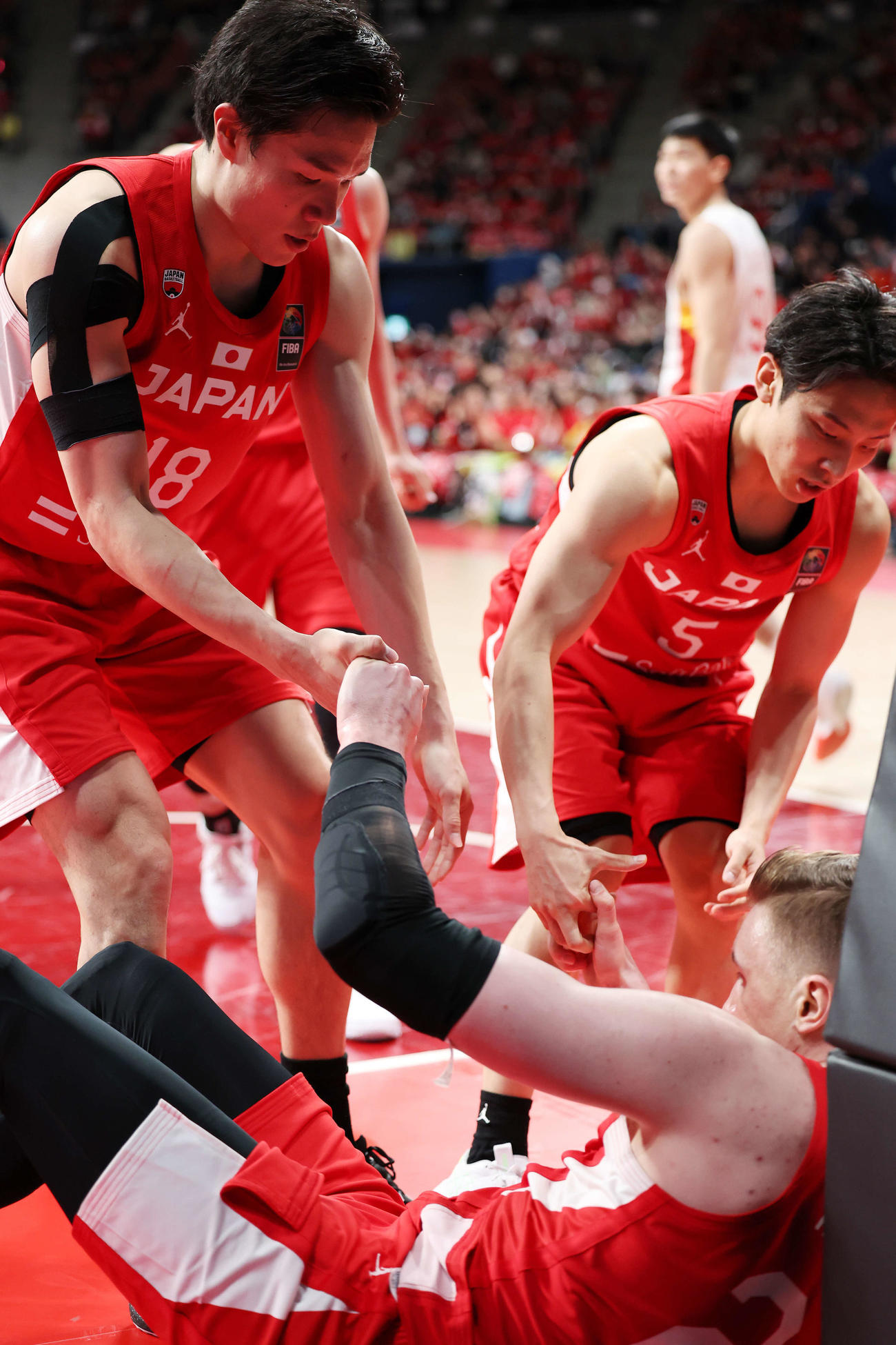 日本対中国　第3Q、バスケットカウントを決めたホーキンソン（下）に手を差し出す馬場（左）と河村（撮影・宮地輝）