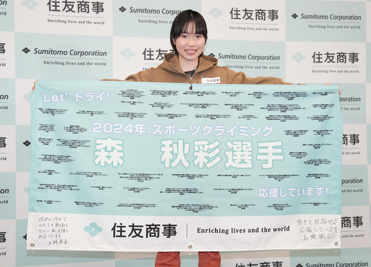 住友商事での激励会で、横断幕を手に写真に納まる森（撮影・鈴木みどり）