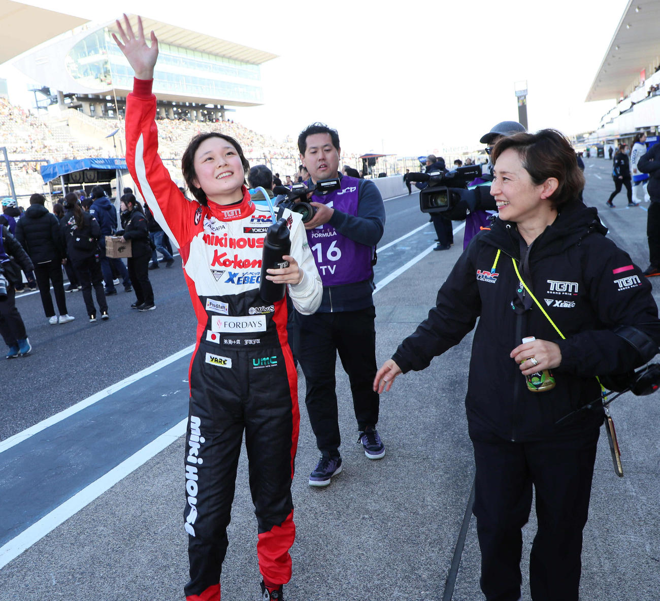 スーパーフォーミュラに初参戦し初完走を果たしたJuju（野田樹潤）は称賛に手を振って応える。右は母の雅恵さん（撮影・宮崎幸一）